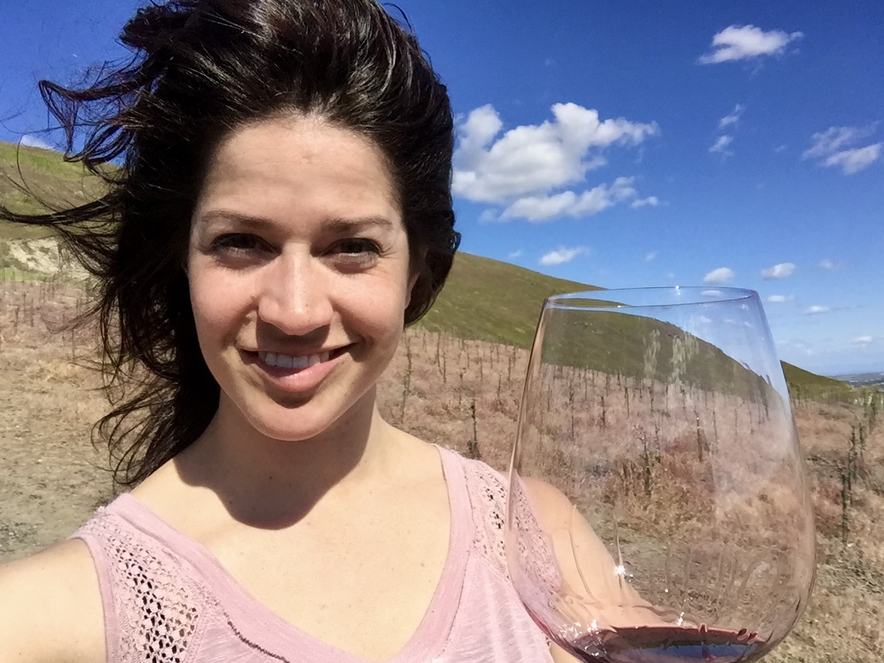 Portrait in vineyard holding a wine glass